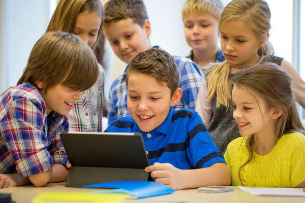 group of school kids with tablet pc in classroom